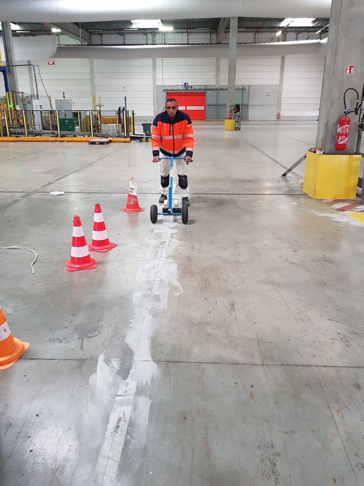 Technicien réalisant le marquage au sol de l'entrepôt